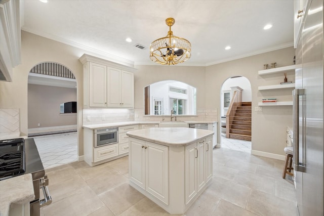 1204 Cowards Creek Dr, Friendswood, TX 77546 - kitchen featuring decorative backsplash, visible vents, stainless steel appliances, arched walkways, and a sink