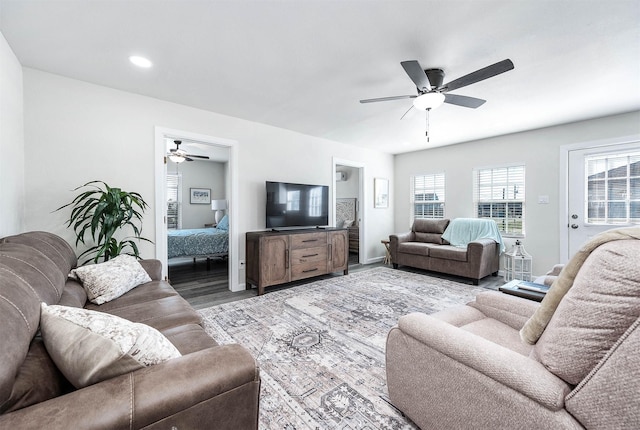 living area with wood finished floors and a ceiling fan