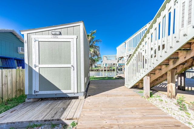 exterior space with stairs, a water view, and fence