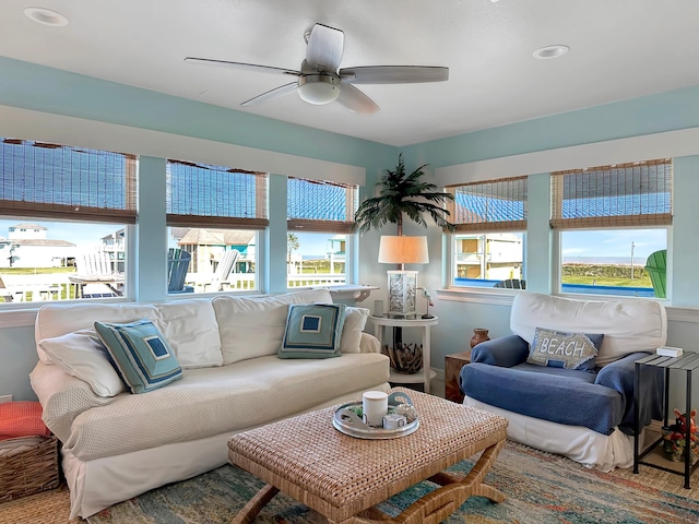 living area featuring a wealth of natural light and a ceiling fan