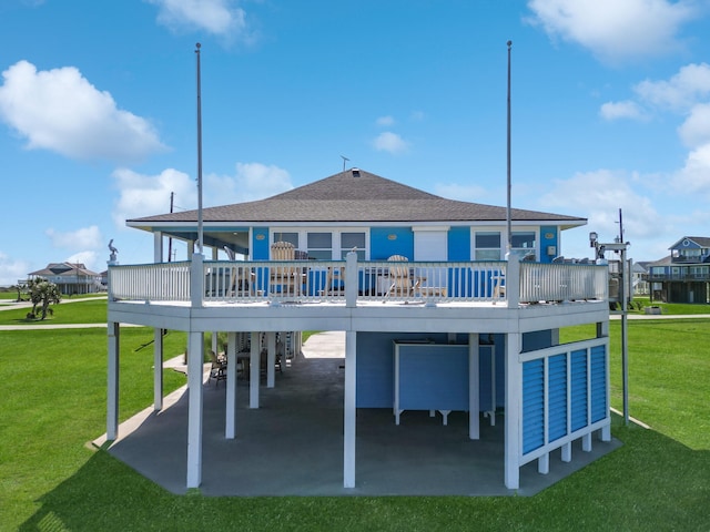 back of house featuring a wooden deck, a carport, a patio area, and a lawn