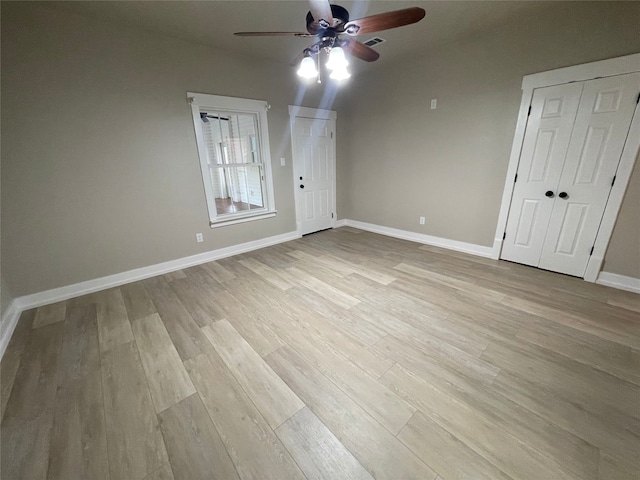 unfurnished bedroom featuring a ceiling fan, light wood-style flooring, baseboards, and visible vents