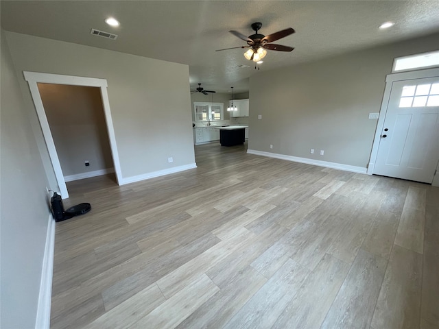 unfurnished living room featuring a ceiling fan, baseboards, light wood-style flooring, and recessed lighting