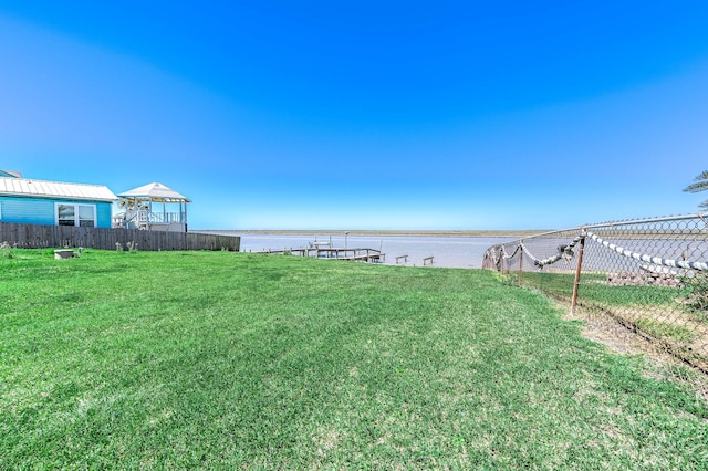 view of yard with fence and a water view