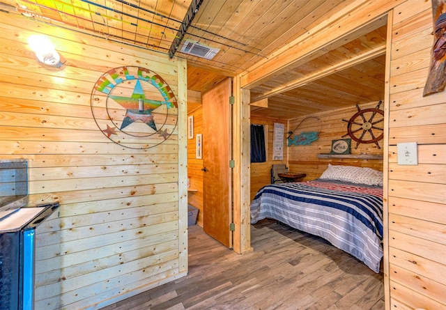 bedroom with wooden ceiling, wood walls, and wood finished floors
