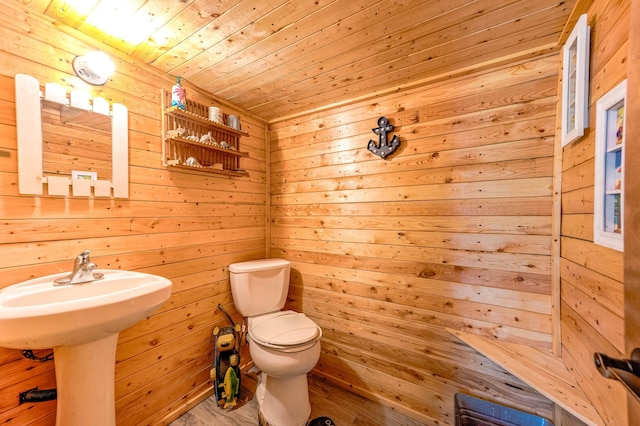 bathroom with wood ceiling, wood finished floors, toilet, and wood walls