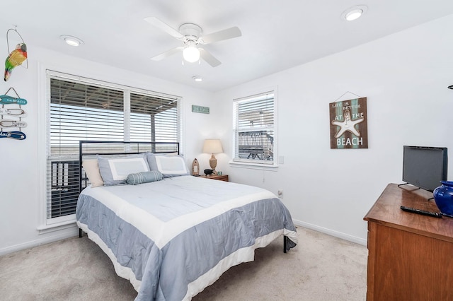 bedroom featuring light colored carpet, ceiling fan, and baseboards