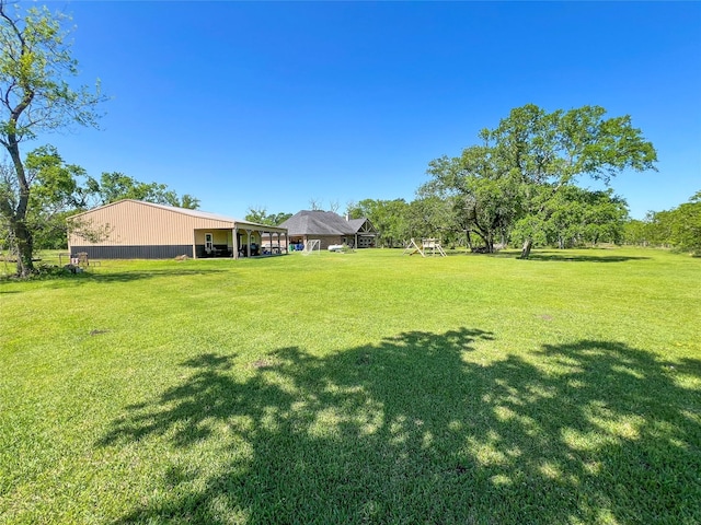 view of yard featuring a carport and an outbuilding