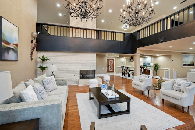 5914 Bermuda Dunes Dr, Houston, TX 77069 - living room with a brick fireplace, a chandelier, a high ceiling, and wood finished floors