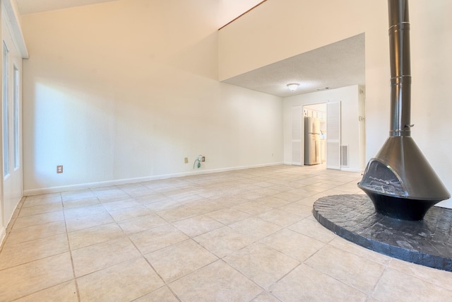 5860 Sampley Way Unit 5860, Houston, TX 77092 - unfurnished living room featuring visible vents, a wood stove, baseboards, and light tile patterned floors