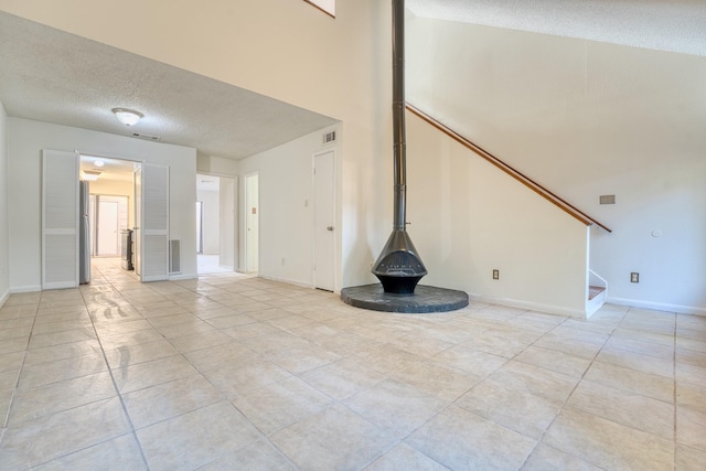5860 Sampley Way Unit 5860, Houston, TX 77092 - unfurnished living room with a textured ceiling, baseboards, visible vents, stairway, and light tile patterned floors
