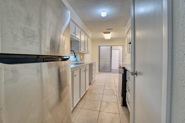 5860 Sampley Way Unit 5860, Houston, TX 77092 - kitchen with white cabinets, a textured ceiling, appliances with stainless steel finishes, and a sink