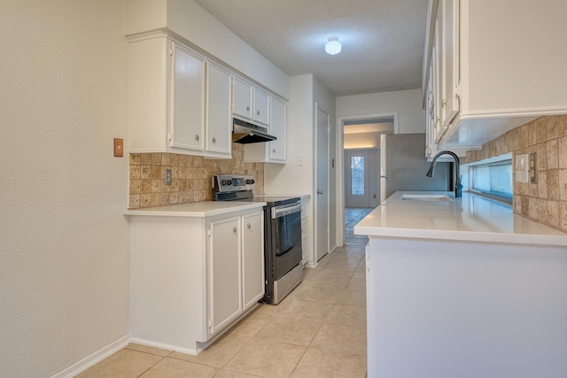 5860 Sampley Way Unit 5860, Houston, TX 77092 - kitchen with stainless steel appliances, a sink, a textured ceiling, decorative backsplash, and under cabinet range hood