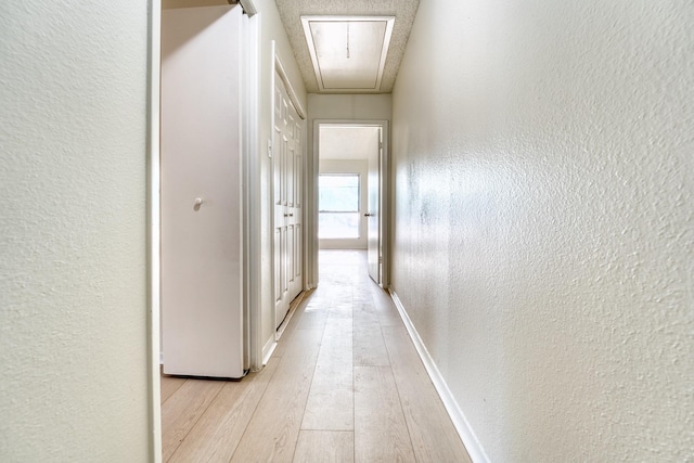 5860 Sampley Way Unit 5860, Houston, TX 77092 - hallway featuring attic access, a textured wall, baseboards, and light wood-type flooring