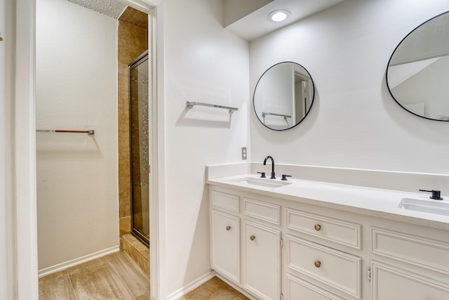 5860 Sampley Way Unit 5860, Houston, TX 77092 - bathroom featuring baseboards, a sink, double vanity, and a stall shower