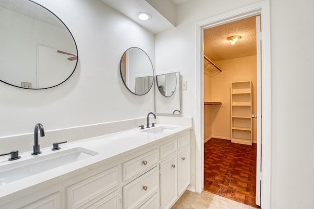 5860 Sampley Way Unit 5860, Houston, TX 77092 - bathroom featuring a spacious closet, a sink, a textured ceiling, and double vanity