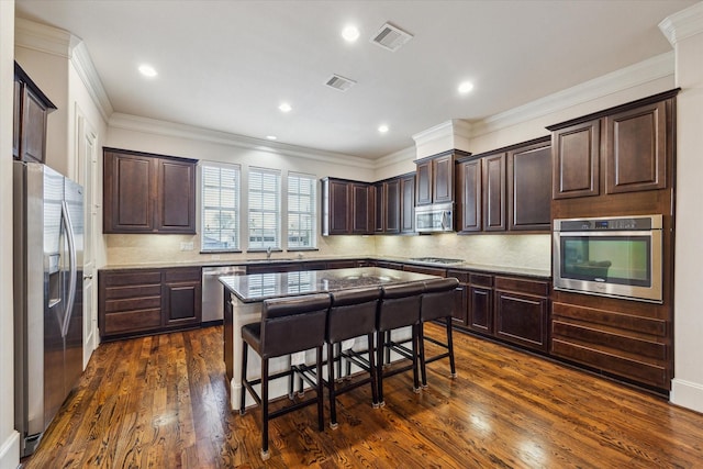 kitchen featuring visible vents, dark brown cabinets, dark wood-type flooring, a sink, and stainless steel appliances