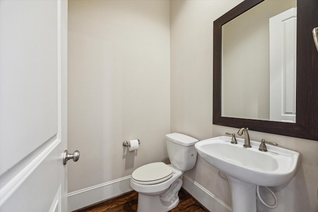 bathroom featuring baseboards, toilet, and wood finished floors