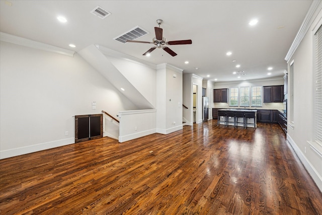 unfurnished living room featuring crown molding and visible vents