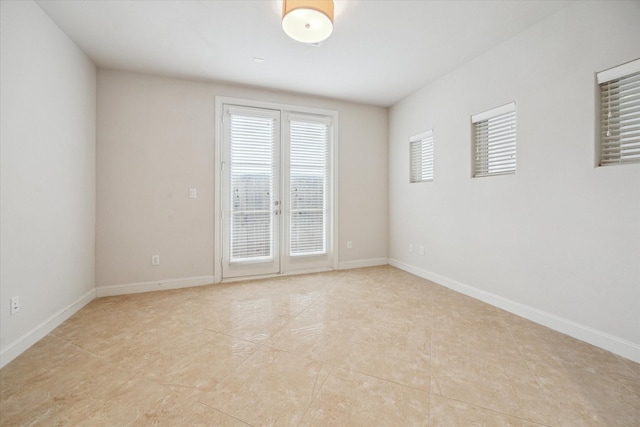 unfurnished room featuring baseboards and light tile patterned flooring