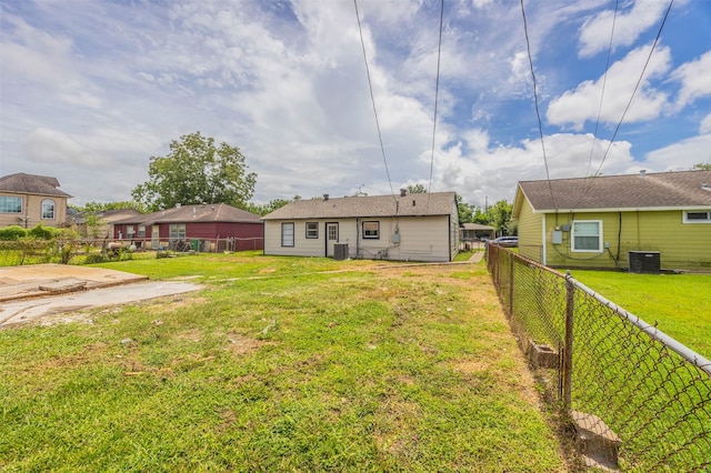rear view of property with a lawn, a fenced backyard, and cooling unit