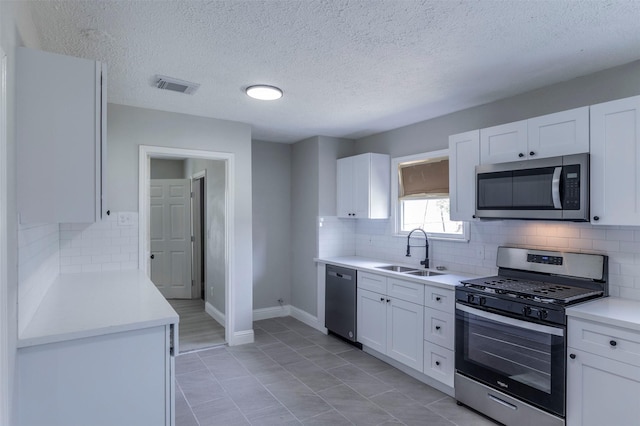 kitchen with visible vents, a sink, white cabinetry, and appliances with stainless steel finishes