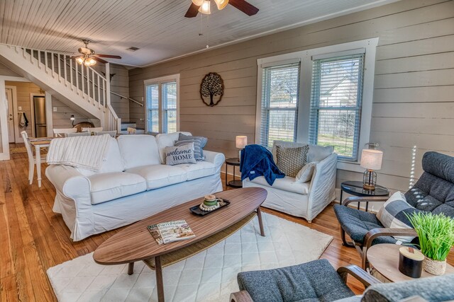 607 Center St, Brenham, TX 77833 - living area with wooden walls, a ceiling fan, light wood-style flooring, and stairs