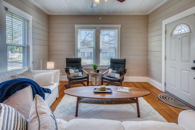 607 Center St, Brenham, TX 77833 - living area featuring wooden walls, a ceiling fan, baseboards, and light wood-style floors
