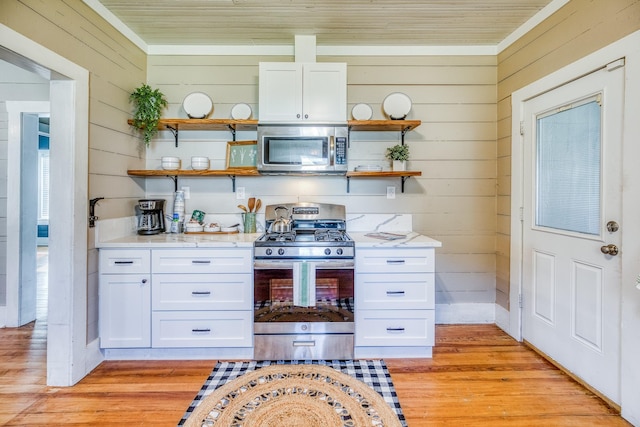 607 Center St, Brenham, TX 77833 - kitchen featuring open shelves, wooden walls, and appliances with stainless steel finishes