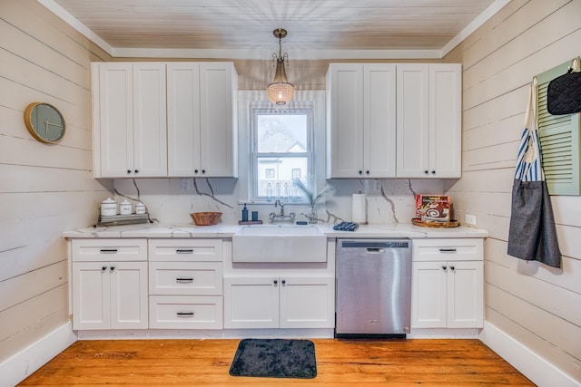 607 Center St, Brenham, TX 77833 - kitchen featuring wooden walls, stainless steel dishwasher, white cabinets, and a sink