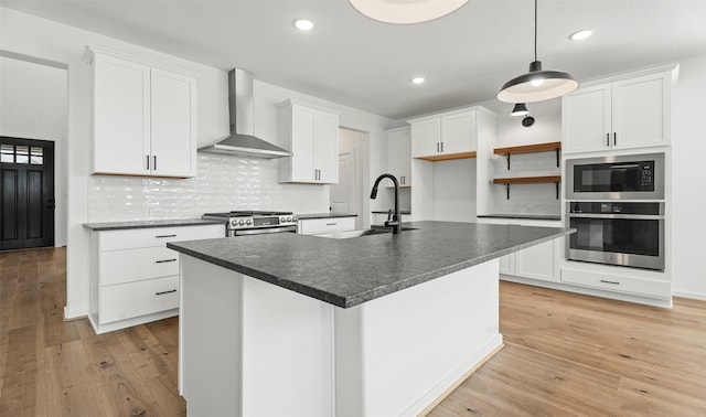 924 Wormwood Dr, League City, TX 77573 - kitchen featuring appliances with stainless steel finishes, wall chimney exhaust hood, dark countertops, recessed lighting, and light wood-type flooring