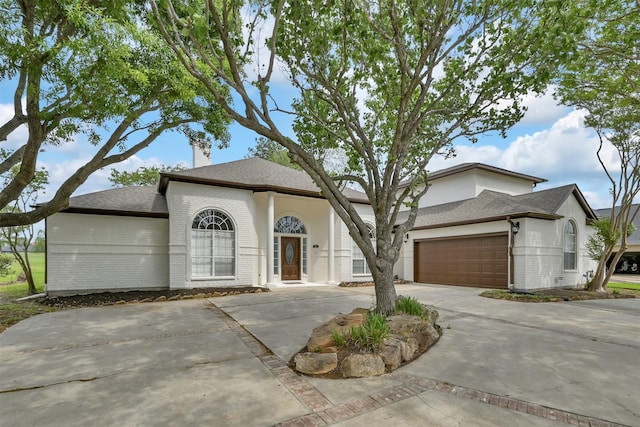 108 Somerton Dr, Montgomery, TX 77356 - view of front of house with brick siding, driveway, a garage, a chimney, and a shingled roof