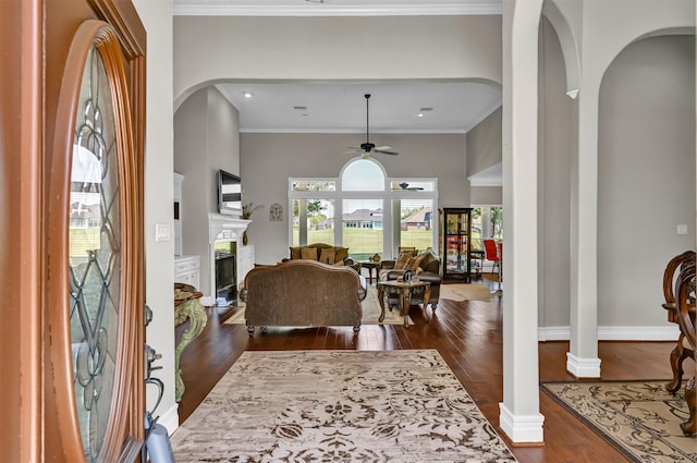 108 Somerton Dr, Montgomery, TX 77356 - foyer with arched walkways, dark wood-style flooring, ceiling fan, a fireplace, and ornate columns