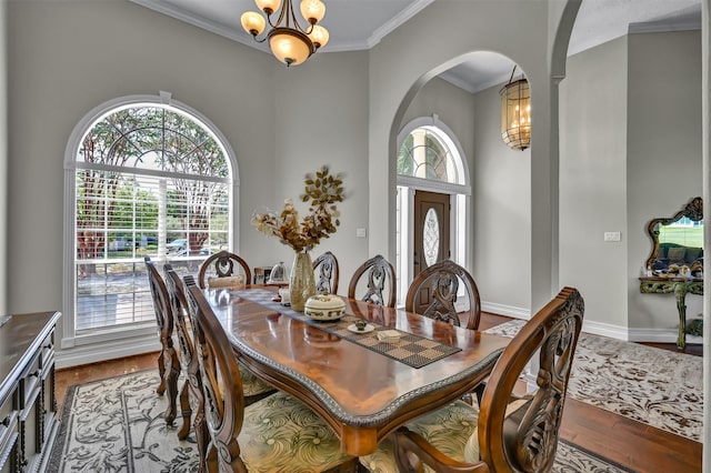 108 Somerton Dr, Montgomery, TX 77356 - dining area with a chandelier, wood finished floors, ornamental molding, arched walkways, and baseboards