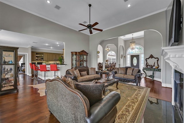 108 Somerton Dr, Montgomery, TX 77356 - living room with arched walkways, recessed lighting, dark wood-style flooring, a ceiling fan, and crown molding