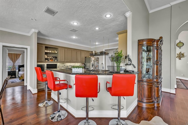 108 Somerton Dr, Montgomery, TX 77356 - kitchen featuring dark wood-style floors, open shelves, a kitchen breakfast bar, baseboards, and crown molding