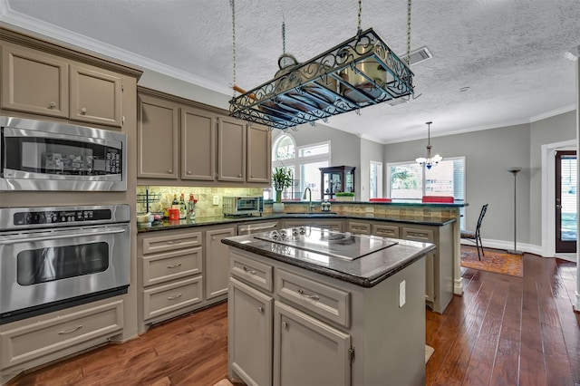 108 Somerton Dr, Montgomery, TX 77356 - kitchen with stainless steel appliances, a peninsula, a chandelier, a sink, and a center island