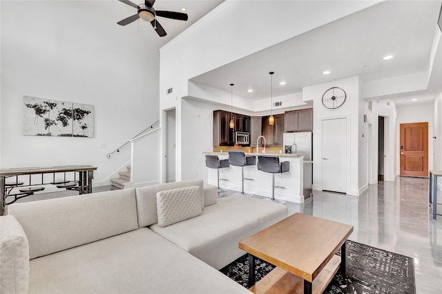 living room with stairway, a ceiling fan, baseboards, visible vents, and recessed lighting