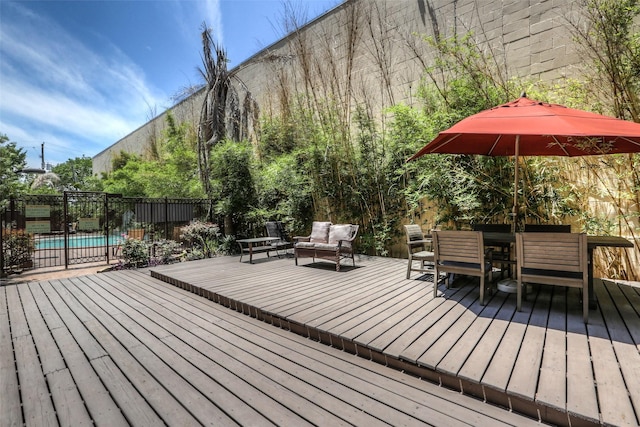 deck featuring outdoor dining space, an outdoor hangout area, fence, and a fenced in pool