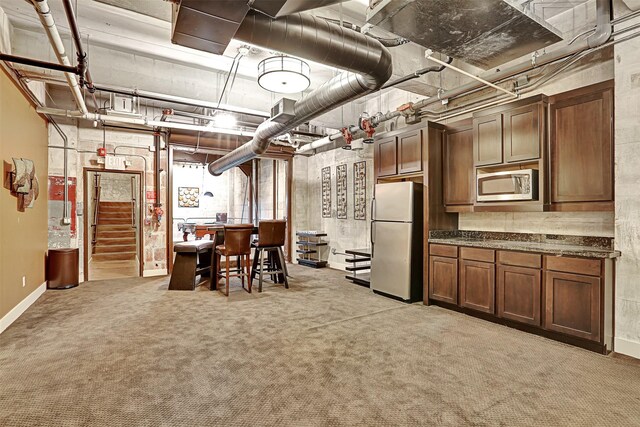unfinished below grade area with baseboards, light colored carpet, stairway, and freestanding refrigerator