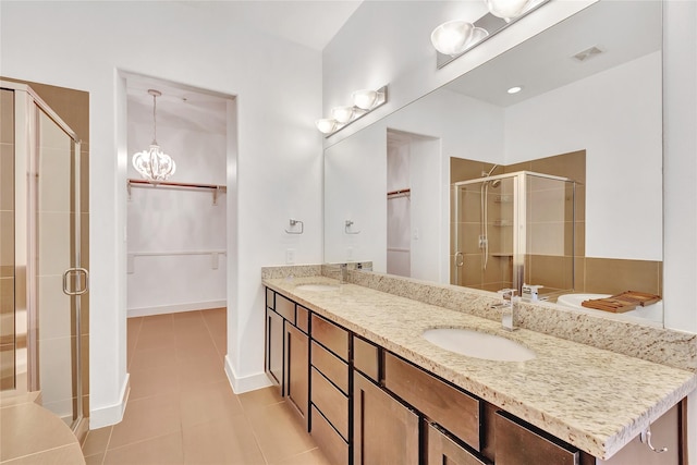 bathroom with double vanity, a sink, tile patterned floors, and a shower stall