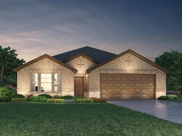 french country inspired facade with concrete driveway, an attached garage, brick siding, a shingled roof, and a yard