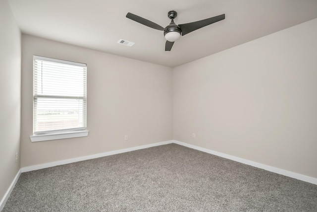 unfurnished room with ceiling fan, carpet floors, visible vents, and baseboards