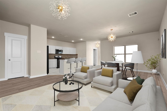 living room featuring baseboards, recessed lighting, visible vents, light wood-style floors, and a notable chandelier