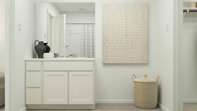full bathroom with baseboards, vanity, curtained shower, and wood finished floors