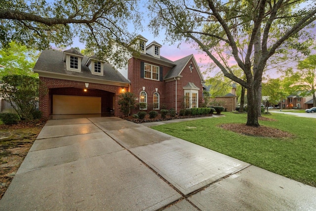 view of front facade with concrete driveway, a garage, brick siding, and a lawn