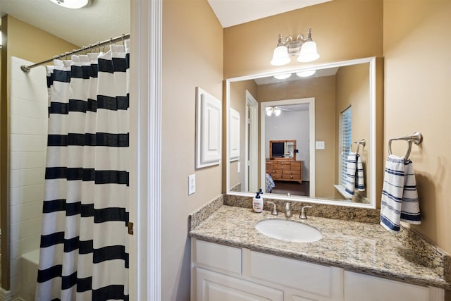 ensuite bathroom with connected bathroom, curtained shower, vanity, and ceiling fan