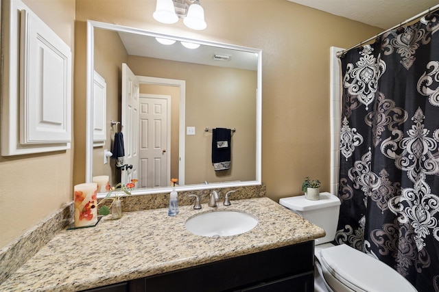 bathroom with toilet, a shower with curtain, vanity, and visible vents