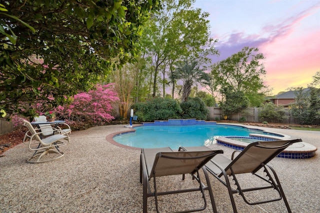 view of pool with a pool with connected hot tub, a patio, and a fenced backyard