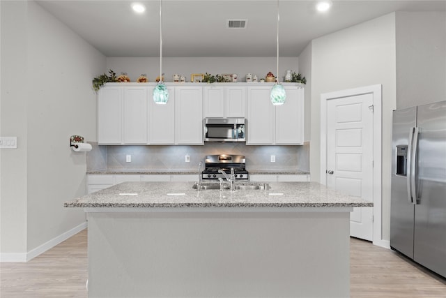 119 Comber Rd, Magnolia, TX 77354 - kitchen with decorative backsplash, light wood finished floors, a sink, and appliances with stainless steel finishes